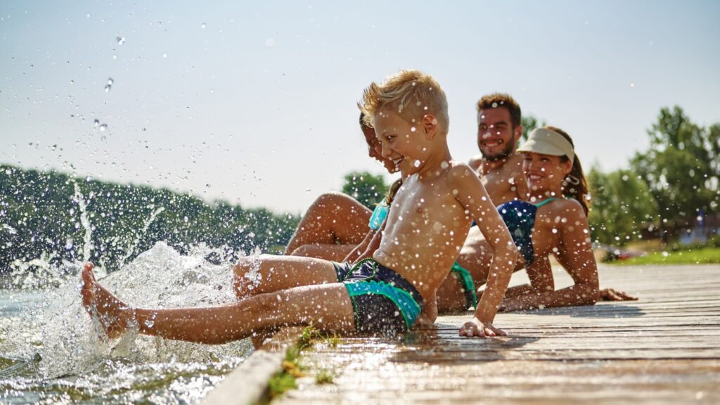 Happy family at a lake having fun and splashing water in summer Robert Kneschke Shutterstock